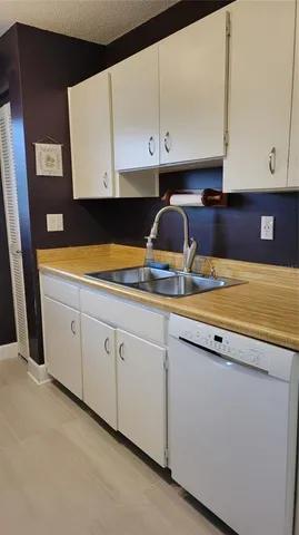 a kitchen with granite countertop white cabinets and white appliances
