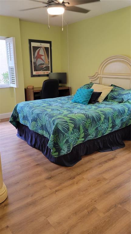 2938 Clark Road, Unit 104 Sarasota, FL 34231 - Photo 10 of 18 a bedroom with a bed and a painting on the wall