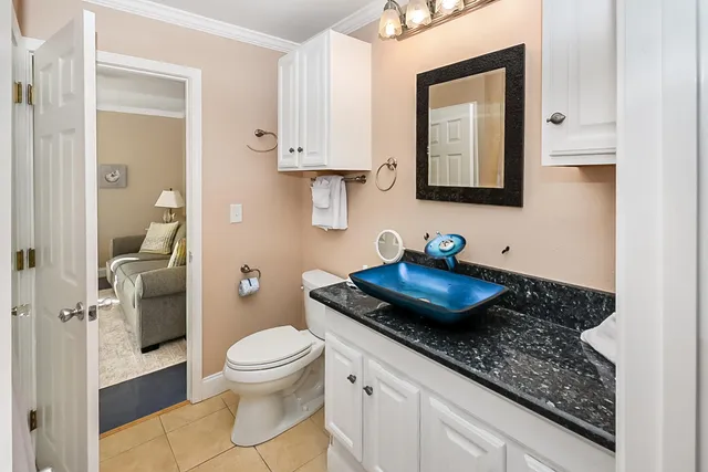 a bathroom with a granite countertop sink a toilet and a mirror