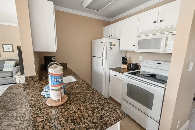 a kitchen with white cabinets and white appliances