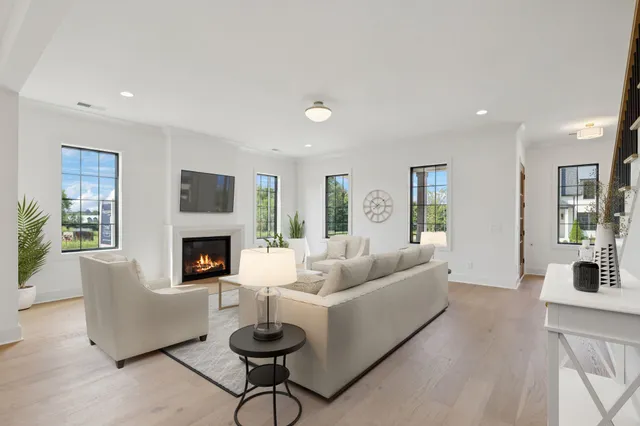 a view of an empty room with wooden floor fireplace and a window