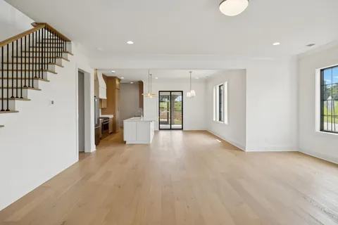 a large white kitchen with a sink and refrigerator