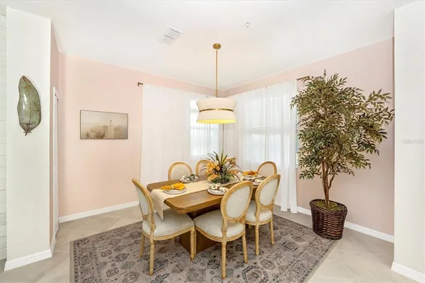 a kitchen with stainless steel appliances kitchen island granite countertop a dining table chairs and white cabinets