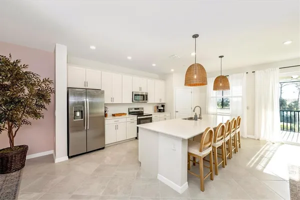 a kitchen with stainless steel appliances granite countertop a sink a stove and a wooden floors