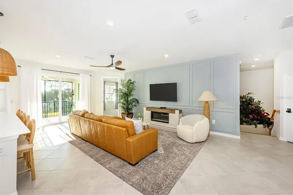 a living room with furniture kitchen view and a potted plant