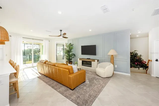 a living room with furniture kitchen view and a potted plant