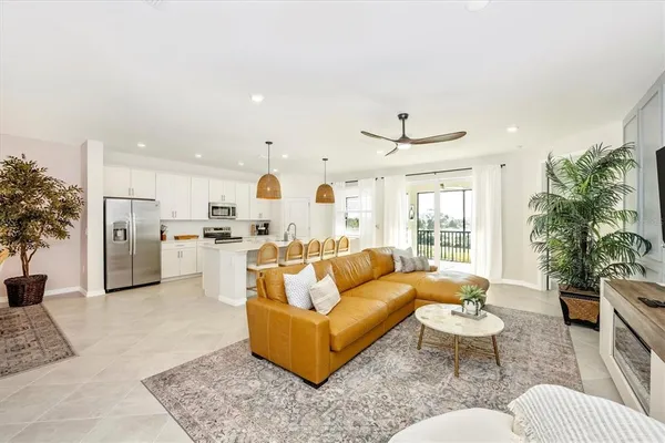 a living room with furniture a flat screen tv and a potted plant