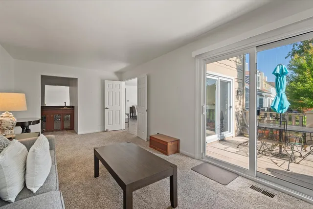 a living room with furniture a flat screen tv and a floor to ceiling window