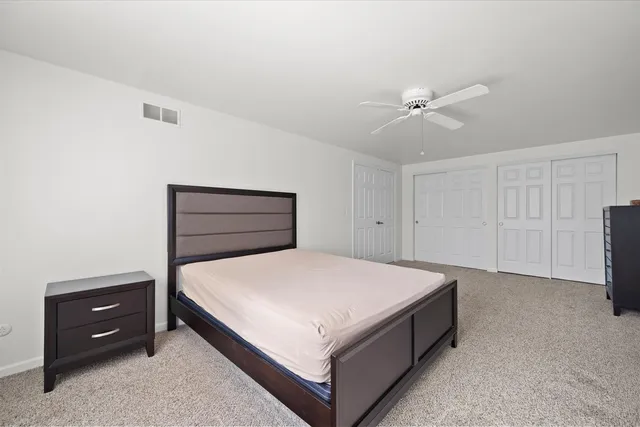 a spacious bedroom with a bed and a dresser