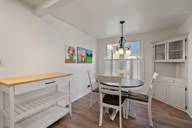a dining room with furniture a chandelier and wooden floor
