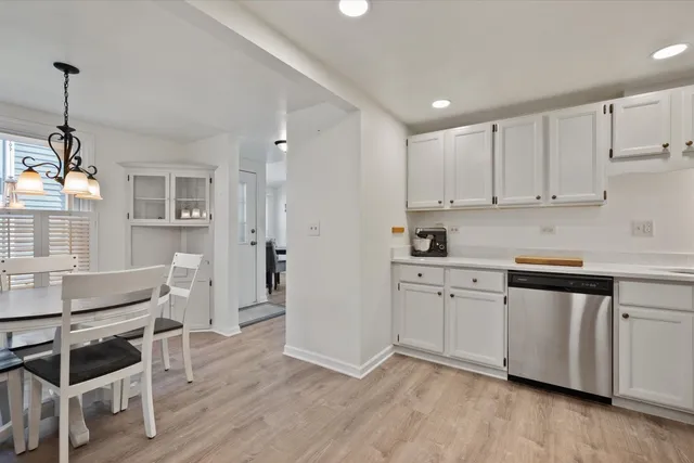 a kitchen with white cabinets and sink
