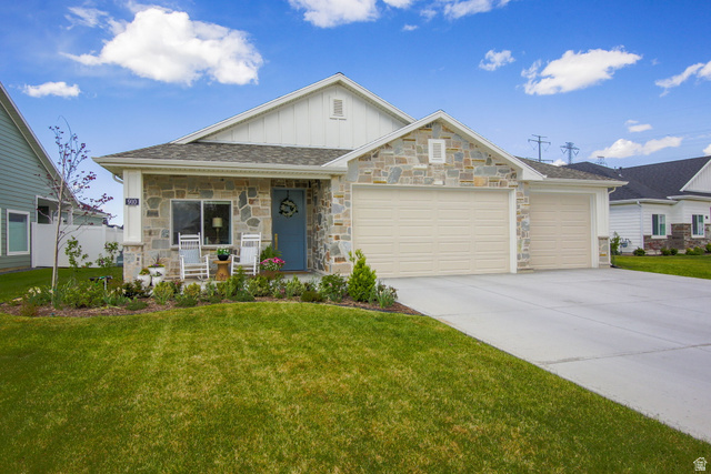 910 South 1700 West Layton, UT 84041 - Photo 1 of 26 View of front of home featuring board and batten siding, a porch, an attached garage, a front yard, and concrete driveway