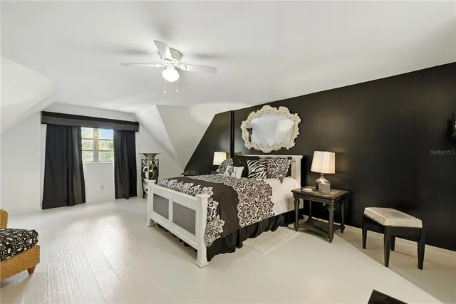 a bedroom with a large bed and a chandelier