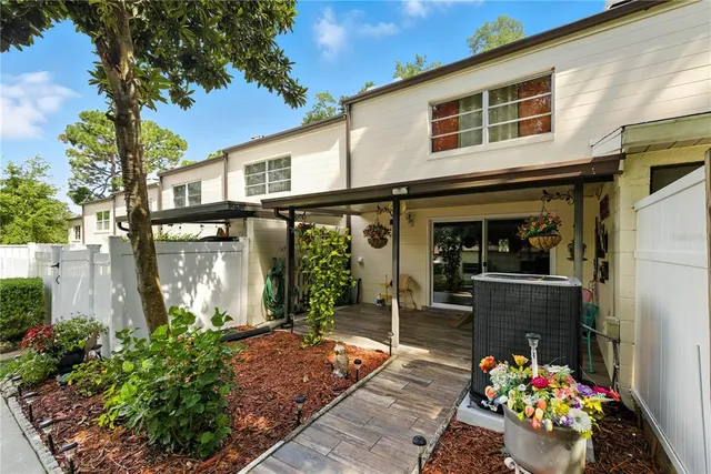 a backyard of a house with potted plants and a bench