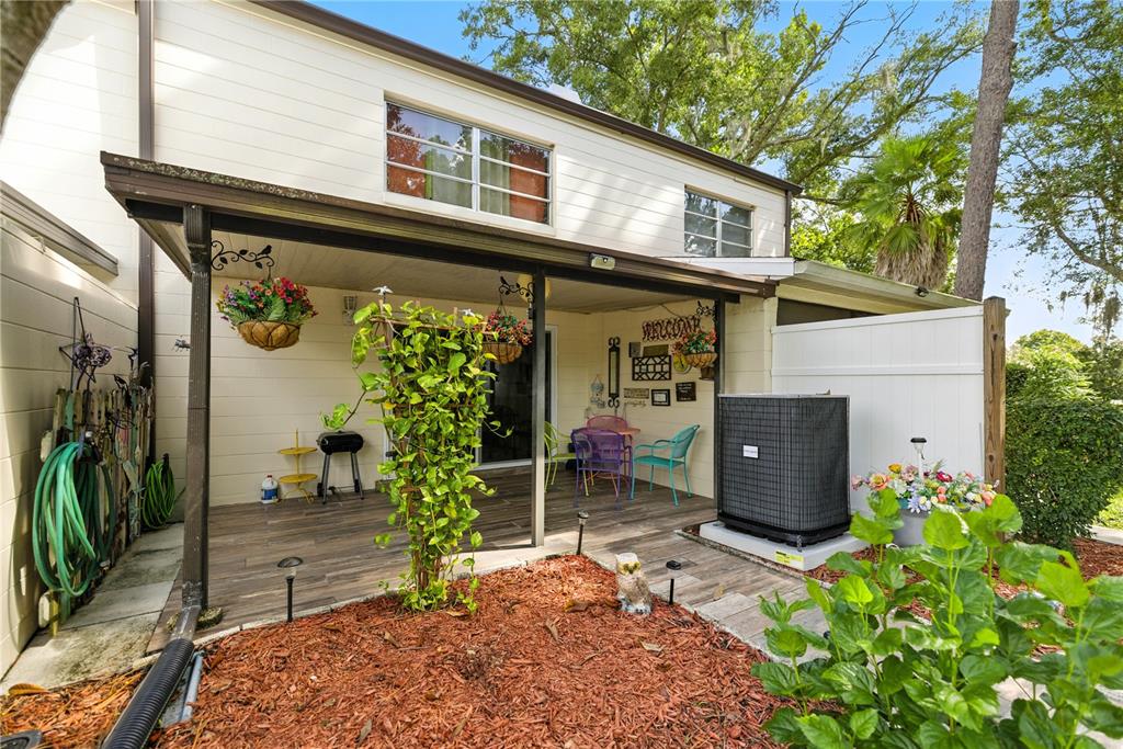 9951 Southwest 88th Court Road, Unit B Ocala, FL 34481 - Photo 27 of 29 a backyard of a house with potted plants and a bench
