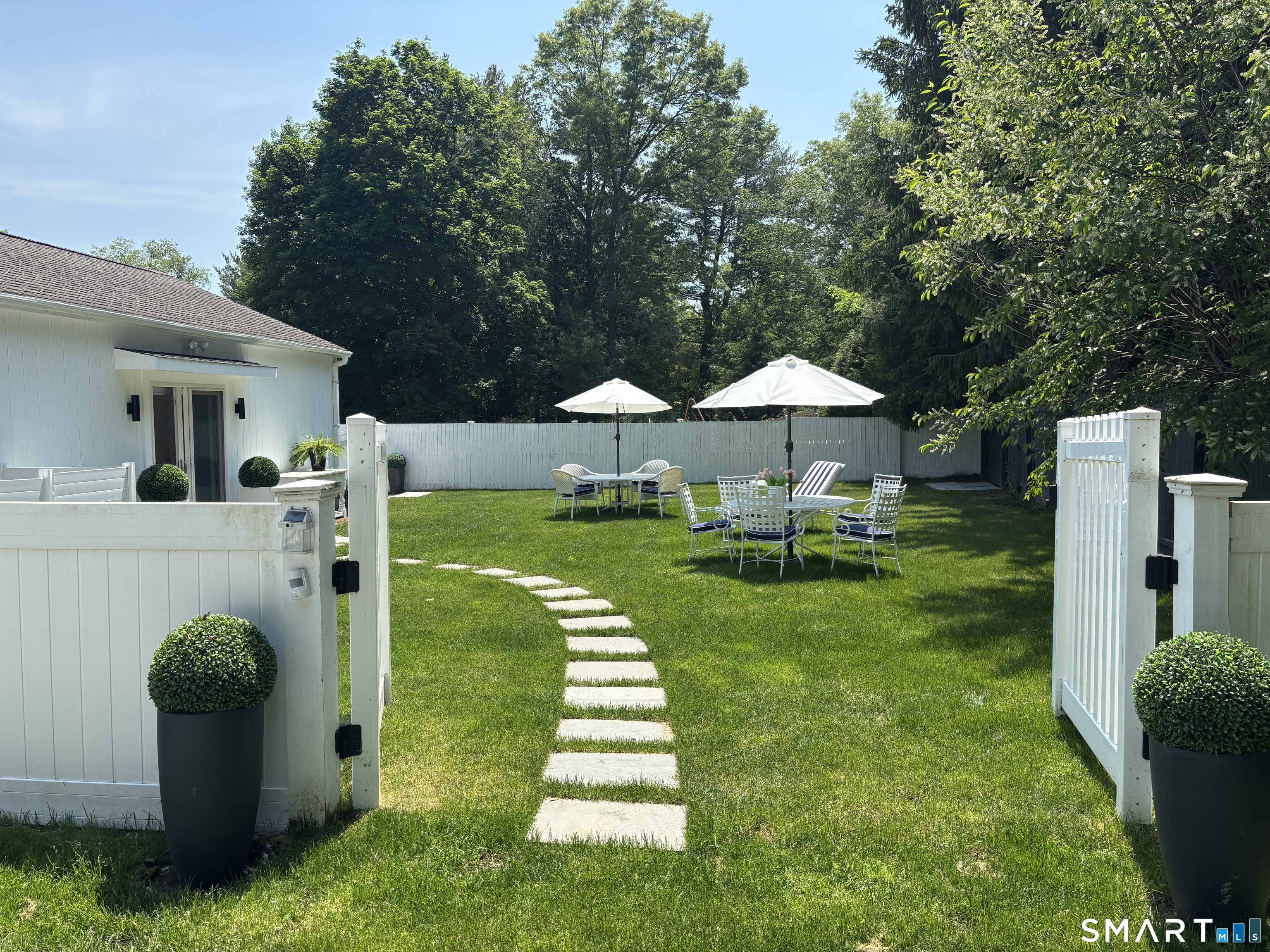 4 A Stoneboat Road Westport, CT 06880 - Photo 22 of 24 a view of a chair and table under an umbrella