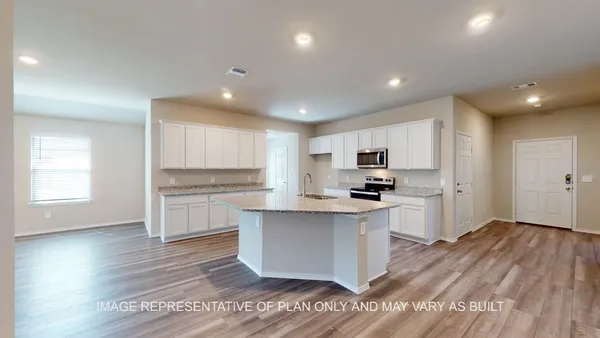 a view of kitchen and empty room with wooden floor