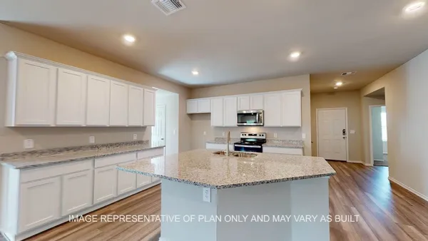 a kitchen with kitchen island granite countertop a sink a counter top space appliances and cabinets
