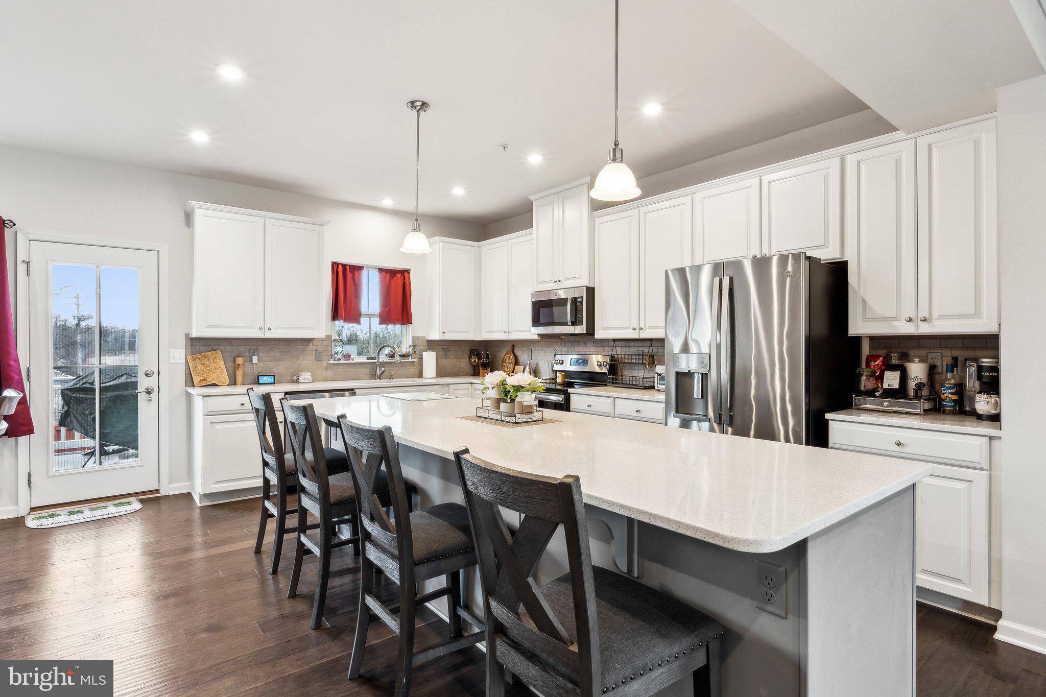 3012 Shaws Road Edgemere, MD 21219 - Photo 8 of 57 a kitchen with stainless steel appliances a table chairs refrigerator microwave and cabinets