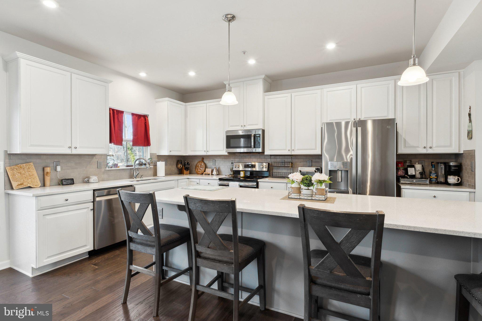 3012 Shaws Road Edgemere, MD 21219 - Photo 9 of 57 a kitchen with a dining table chairs refrigerator and microwave