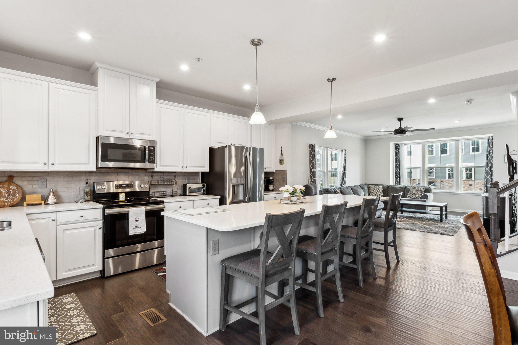 3012 Shaws Road Edgemere, MD 21219 - Photo 10 of 57 a kitchen with stainless steel appliances a dining table chairs stove microwave and cabinets