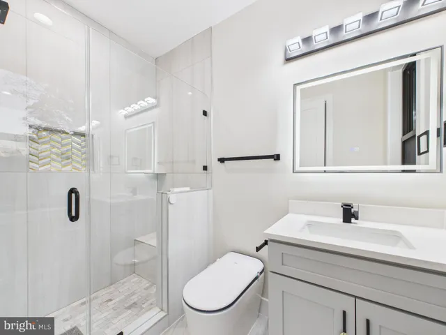 a large white kitchen with kitchen island a large counter top space a sink stainless steel appliances and cabinets