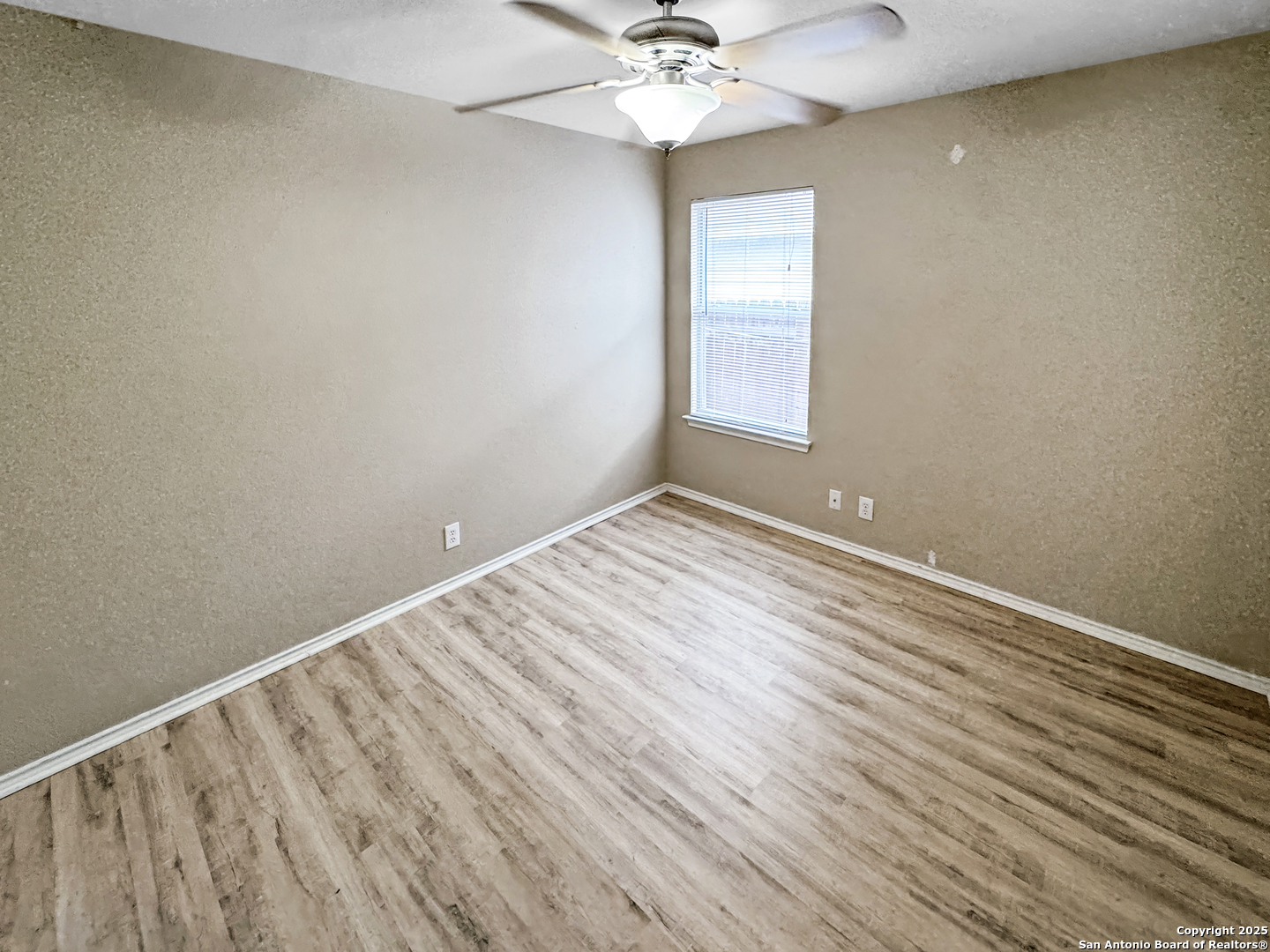 312 Hummingbird Drive New Braunfels, TX 78130 - Photo 5 of 20 wooden floor in an empty room with a window