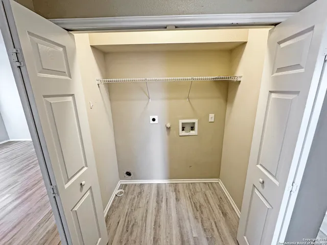 a view of walk in closet with wooden floor and door