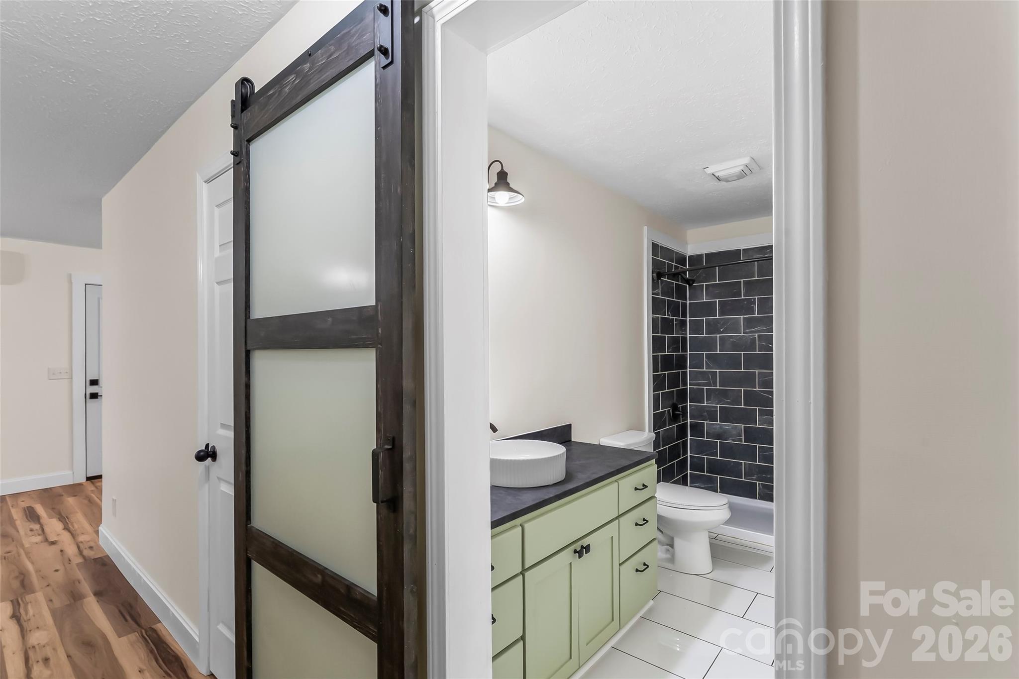 825 South Creek Road Nebo, NC 28761 - Photo 19 of 34 a bathroom with a granite countertop toilet a sink and a mirror
