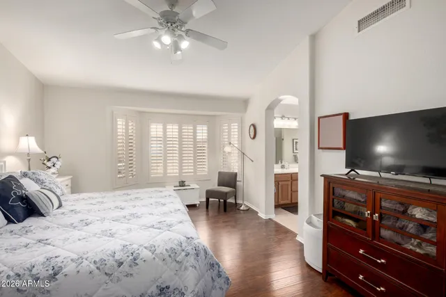 a spacious bedroom with a bed and a flat screen tv