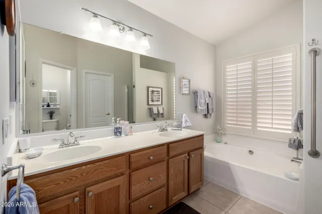 a bathroom with a tub double sink and mirror