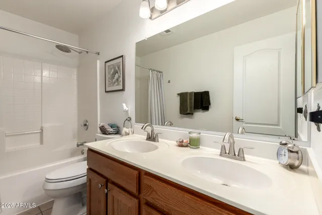 a bathroom with a double vanity sink toilet and mirror