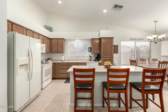 a kitchen with a refrigerator a stove a dining table and chairs