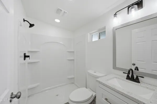 a bathroom with a sink a toilet and shower