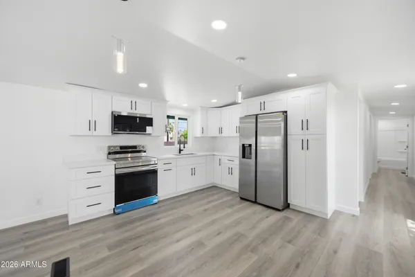 a kitchen with stainless steel appliances a refrigerator sink and stove