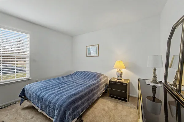 a bedroom with a bed next to a window