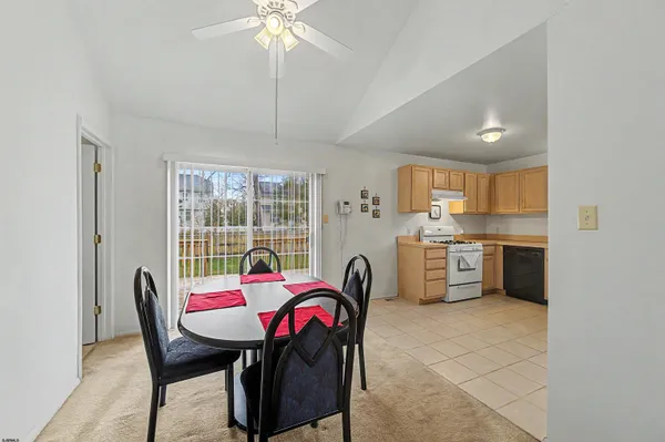 a living room with furniture a chandelier and a kitchen view