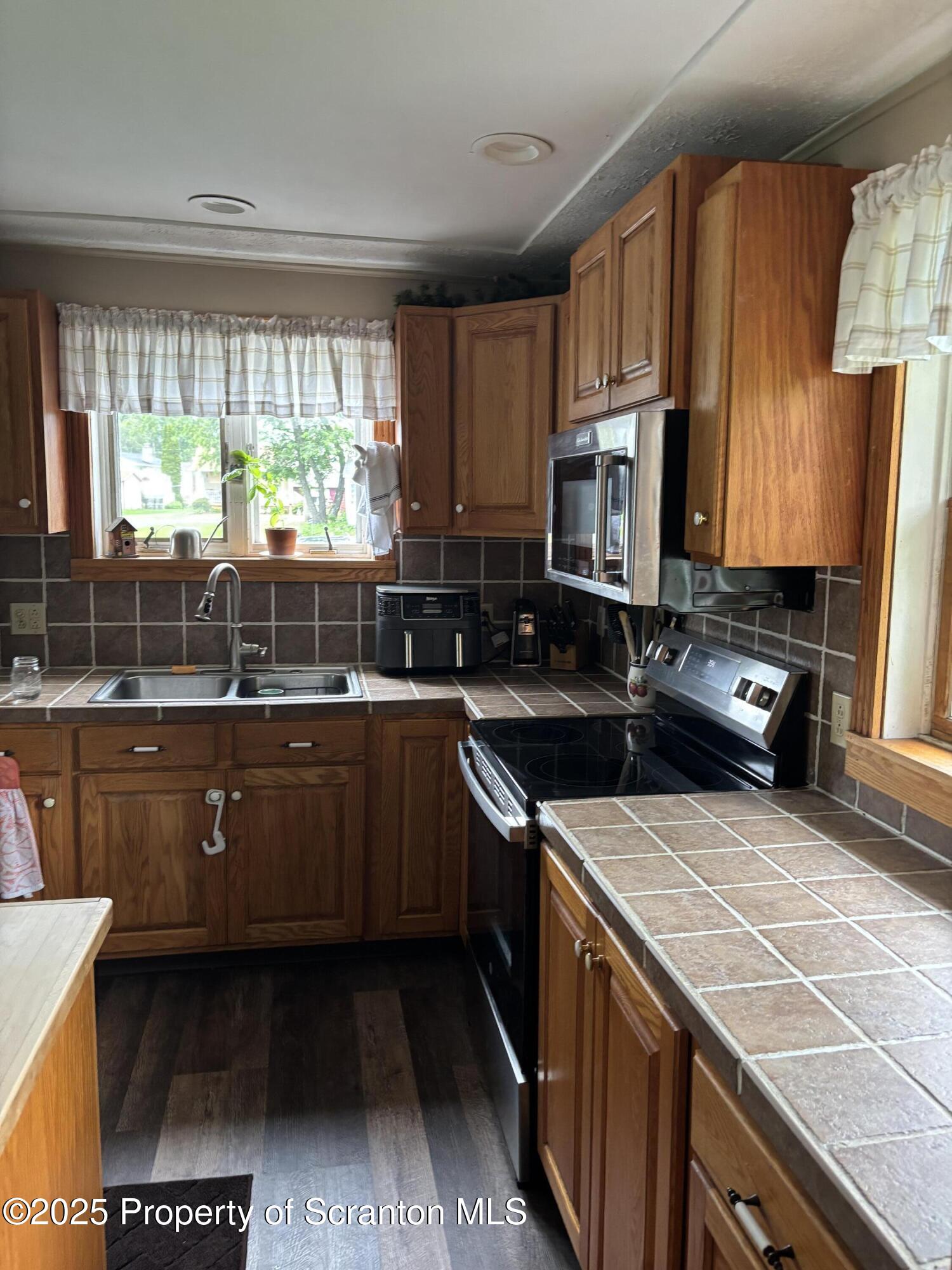 5036 Rear Birney Moosic, PA 18507 - Photo 21 of 35 a kitchen with a sink a stove a microwave and wooden cabinets