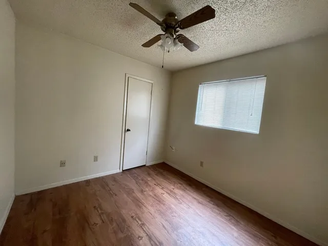 an empty room with a ceiling fan and carpet