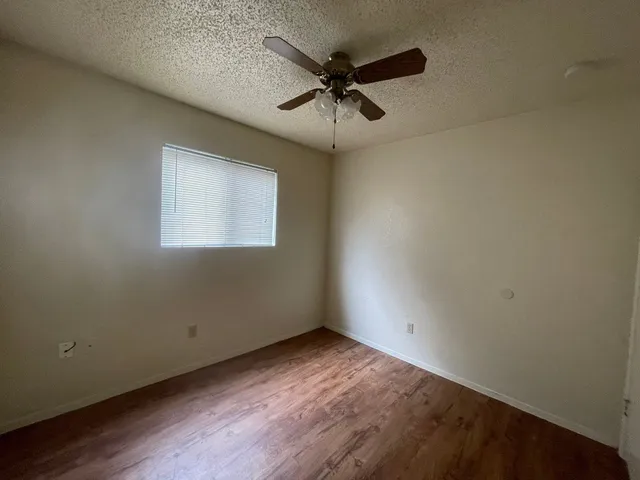 an empty room with a window and a fan