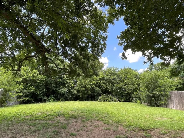 a view of green field with trees in the background
