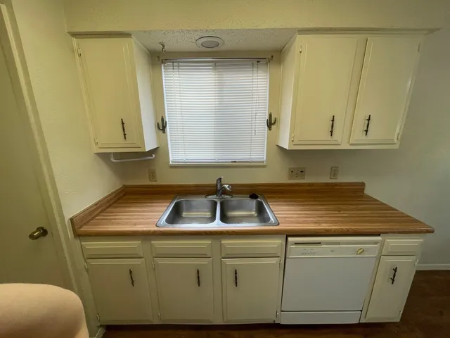 a kitchen with white cabinets and a sink