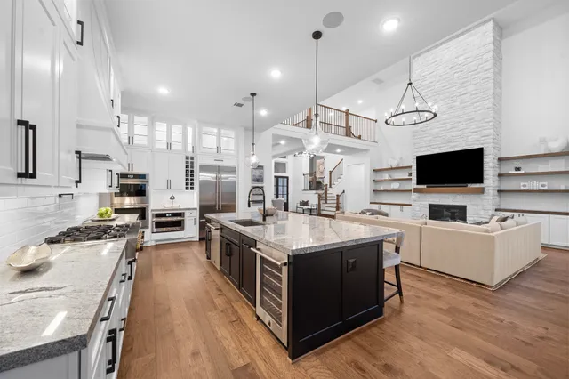 a kitchen with stainless steel appliances granite countertop a stove oven and a view of living room