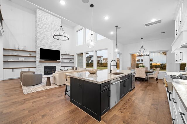 a kitchen with stainless steel appliances kitchen island granite countertop a stove and a view of living room