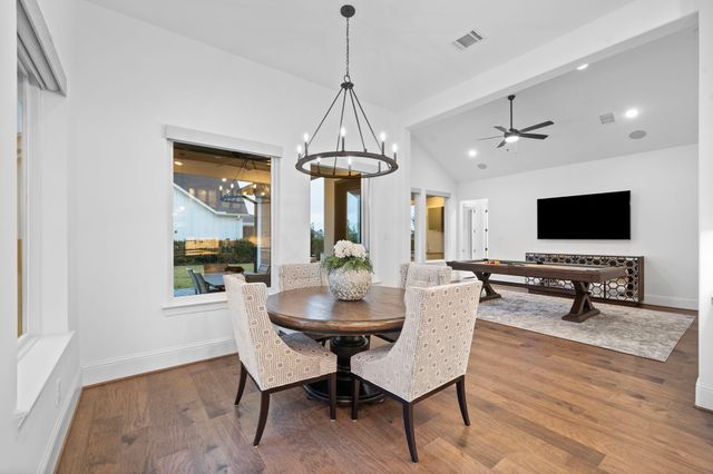 a dining room with furniture a chandelier and wooden floor