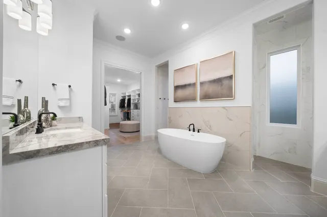 a spacious bathroom with a double vanity sink mirror and bathtub