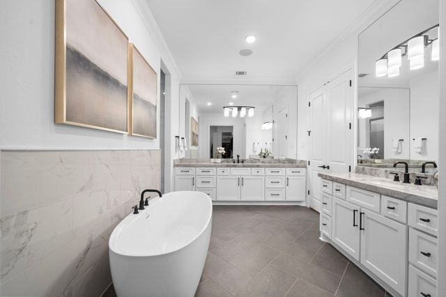 a spacious bathroom with a double vanity sink a mirror a bathtub and