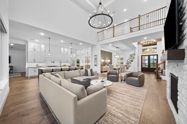 a living room with furniture kitchen view and a chandelier