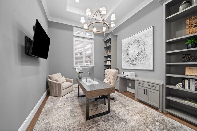 a living room with furniture a flat screen tv and kitchen view