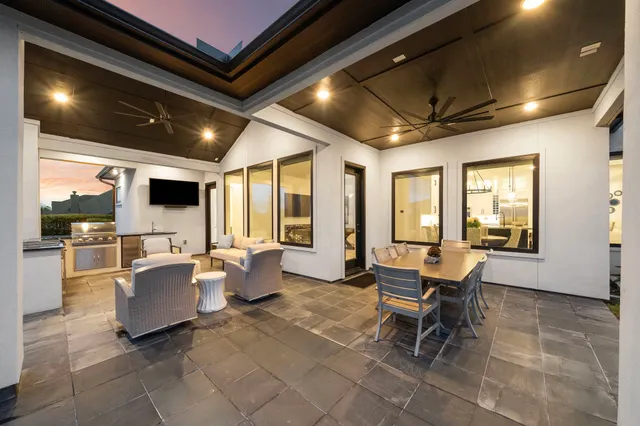 a living room with patio furniture and a flat screen tv